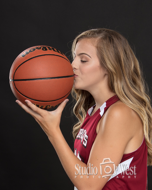 girl kissing basketball in studio portrait paso robles senior yearbook portraits